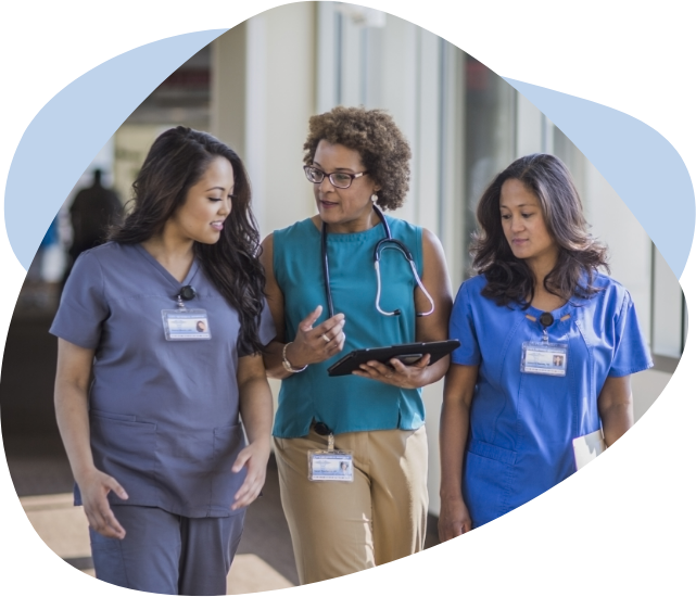 A female doctor speaking to two female nurses while walking