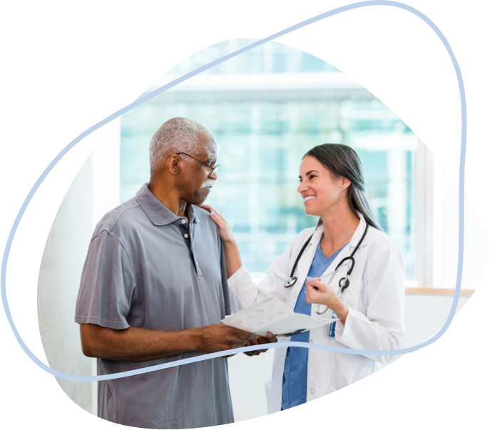 A female doctor smiling and putting her hand on her middle-aged male patient