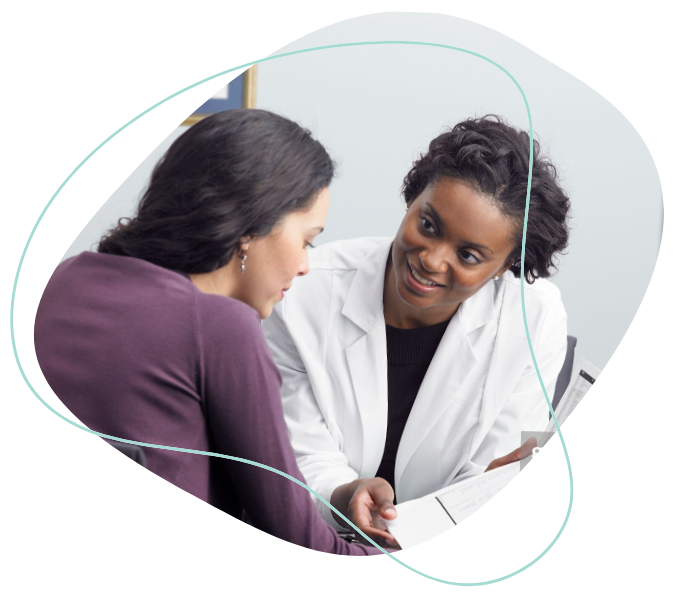 A female patient and her female doctor looking at a document together