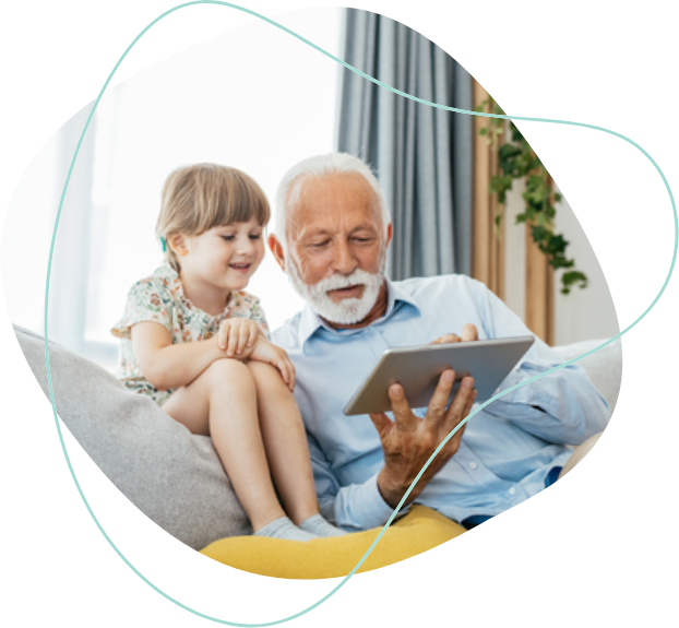 A grandfather and his granddaughter looking at a tablet